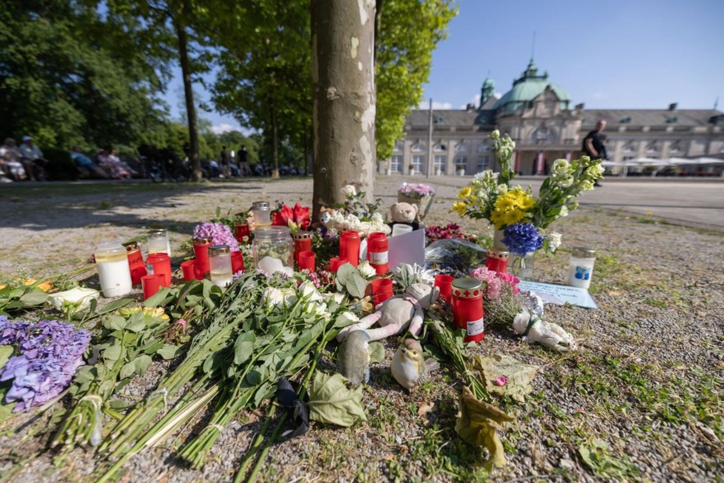 Blumen, Kerzen und handgeschriebene Trauerbekundungen stehen an einem Baum im Kurpark Bad Oeynhausen. Jetzt steht die Anklage.