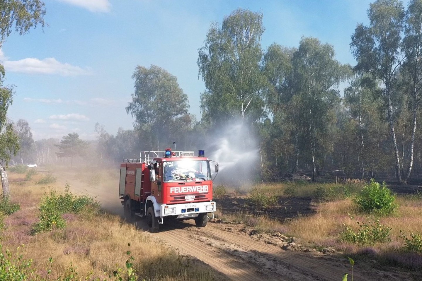 Die Feuerwehr löscht von Wegen aus beim Waldbrand in Jüterbog. 