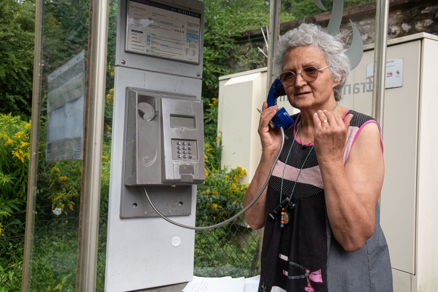 Marie-Claude König nimmt in Murbach einen Anruf entgegen. In der Telefonzelle im Elsass rufen Menschen aus der ganzen Welt an.